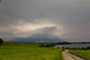 Die Berge werden von den Wolken eingehüllt. Auch der Donner interessiert die Leute auf dem See anscheinend wenig.