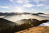 Die Berge werfen immer längere Schatten über den Nebel.