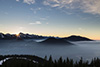Die Sonne geht hinter den Alpen unter.